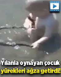 Su içinde yılanla oynayan çocuk