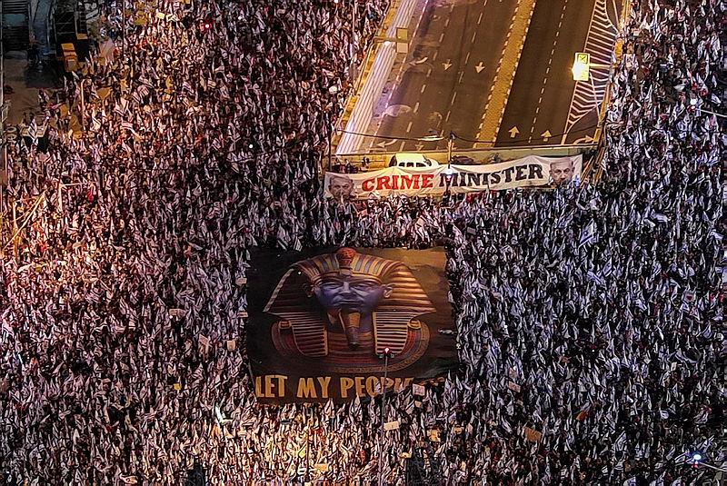 İsrail'in Tel Aviv kentinde İsrail milliyetçi koalisyon hükümetinin yargı değişikliğine karşı düzenlenen gösteri sırasında insanlar, İsrail Başbakanı Binyamin Netanyahu'yu ʺHalkımı bırakʺ yazan bir pankart taşıyor, 8 Nisan 2023