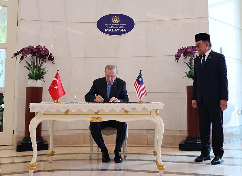 Başkan Erdoğan (solda), resmi temaslarda bulunmak üzere geldiği Malezya'da. (AA)