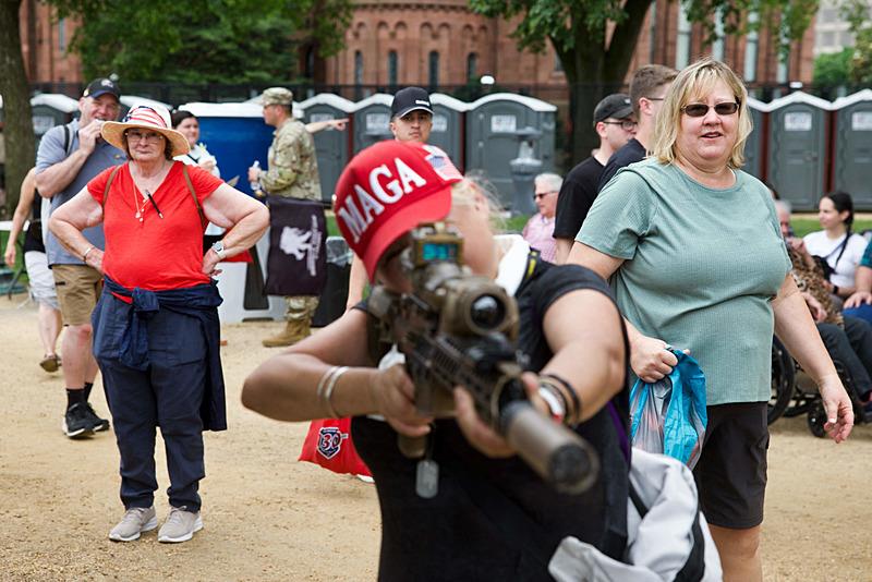 MAGA şapkası takan bir ziyaretçi, 14 Haziran 2025 tarihinde Washington DC'deki National Mall'da düzenlenen Ordunun 250. Yıldönümü Geçit Töreni sırasında bir makineli tüfeği test ediyor, AFP