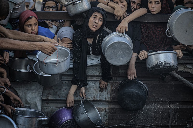 İsrail'in Gazze Şeridi'ne uyguladığı abluka ve devam eden saldırılar nedeniyle gıdaya erişimde zorluk yaşayan Filistinlilere, bir hayır kurumu tarafından yemek dağıtımı yapıldı. Gazze kentinde gerçekleşen dağıtım sırasında yoğunluk oluştu (Fotoğraf: AA)