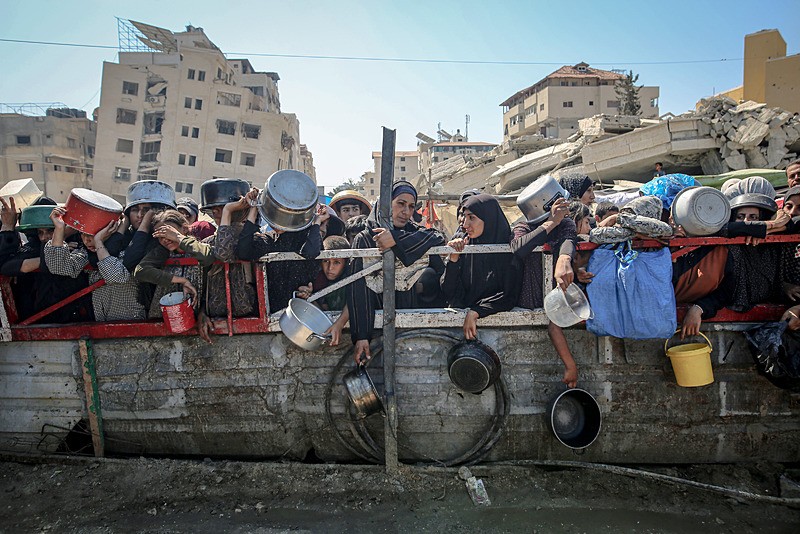 Gazze'de açlıkla mücadele Filistinliler, yemek alabilmek için sıcak havaya rağmen kuyrukta bekliyor, AA