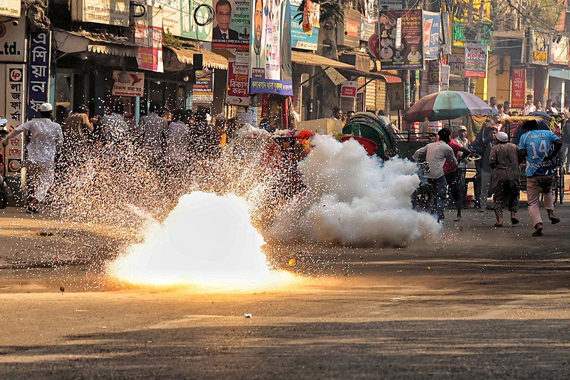 Bangladeş'in Dakka kentinde, devrik Başbakan Şeyh Hasina'ya karşı açılan davaların karara bağlanması öncesinde, polisin göstericileri dağıtmak için attığı ses bombasının yanından koşarak geçen insanlar, 17 Kasım 2025, Reuters